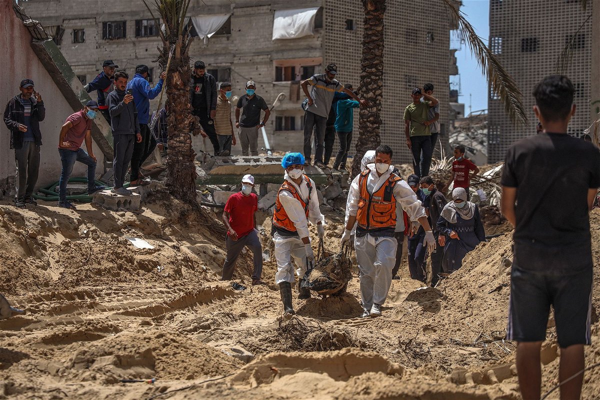 <i>AFP/Getty Images via CNN Newsource</i><br/>People and health workers unearth bodies found at Nasser Hospital in Khan Younis in the southern Gaza Strip on Tuesday.