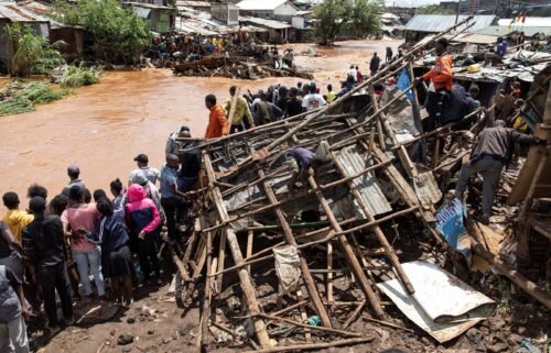 Residents of Mathare stand next to their destroyed houses by the Mathare river