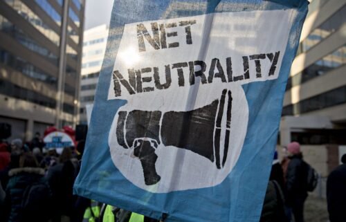 A demonstrator opposed to the roll back of net neutrality rules holds a sign outside the Federal Communications Commission (FCC) headquarters in Washington