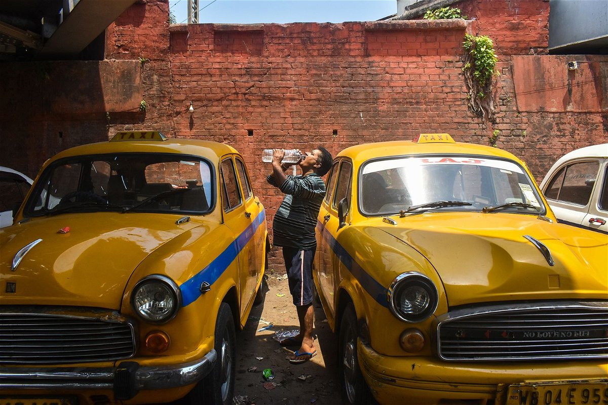 A taxi driver drinks water during a heat wave in Kolkata