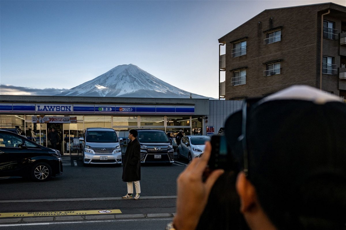 A tourist takes a photo at the spot in Fujikawaguchiko where the barrier is due to go up.