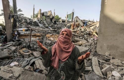 A Palestinian woman inspects a house that was destroyed by an Israeli bombing in Rafah