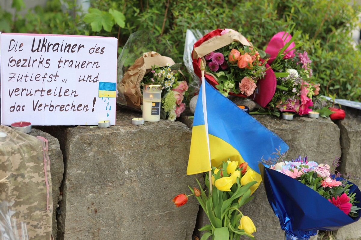 <i>Constanze Wilz/dpa/AP via CNN Newsource</i><br/>Flowers and a small Ukrainian flag are laid at a shopping center in Murnau