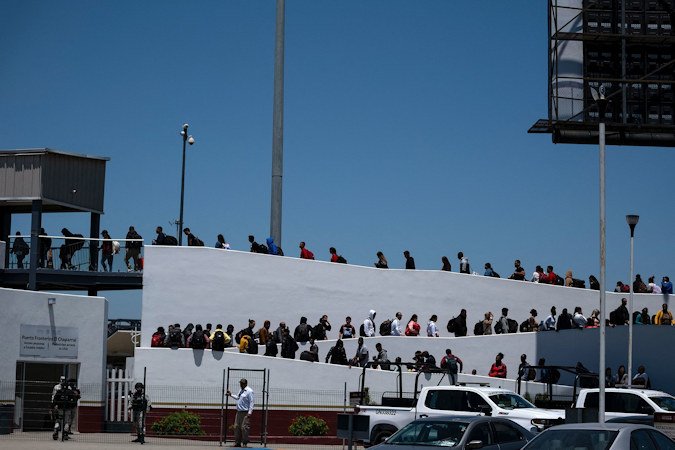 Asylum seekers walk for their asylum interview appointment with US authorities at the El Chaparral crossing port in Tijuana, Baja California State, Mexico, on May 18. The Biden administration is preparing to roll out a sweeping border executive action.