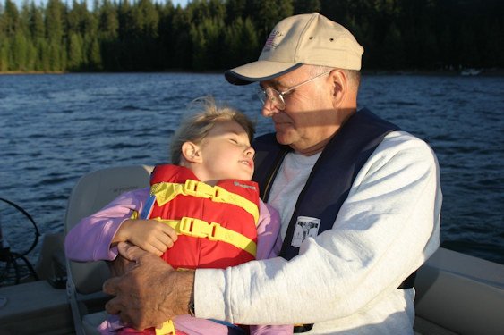Grandfather and granddaughter boating with life jackets