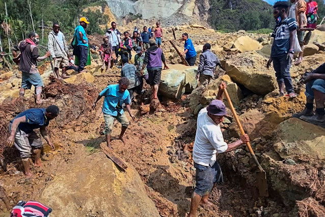Villagers search through a landslide in Yambali, in the Highlands of Papua New Guinea, Sunday, May 26.