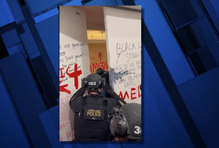 Portland Police officers break through barricaded door on first floor of PSU library Thursday morning