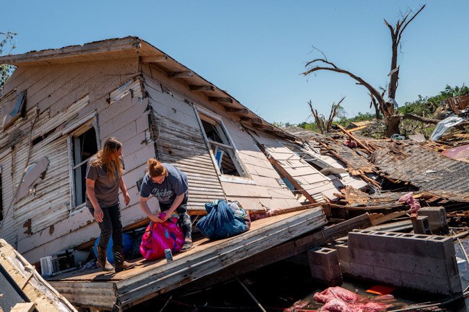 The Crowder family sift through and recover lost items after their home was struck by a tornado on May 7, in Barnsdall, Oklahoma.