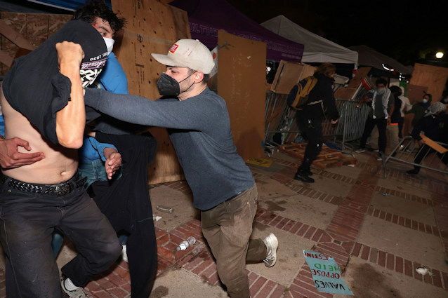 A counterprotester, identified by CNN as Malachi Marlan-Librett, pushes a pro-Palestinian protester in the barrier of the UCLA encampment.