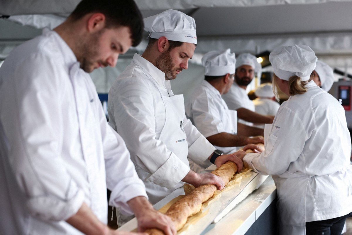 <i>Stephanie Lecocq/Reuters via CNN Newsource</i><br/>French bakers try not to crack the baguette when it comes out of a large rotating oven.