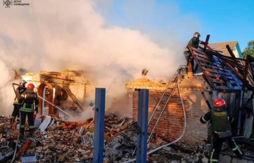 Rescuers assess the ruins of a building