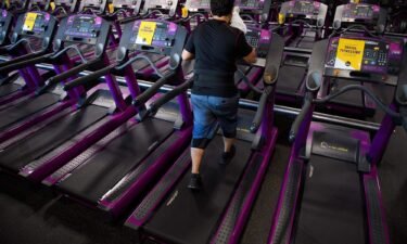 A customer wipes sweat from their face as they work out on a treadmill inside a Planet Fitness Inc. gym in March 2021 in Inglewood