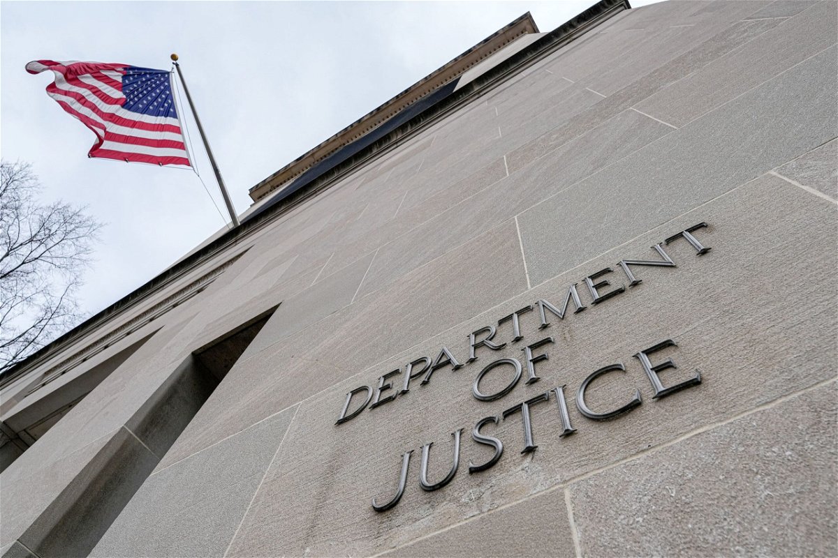 <i>J. David Ake/Getty Images via CNN Newsource</i><br/>The US flag flies above a sign marking the US Department of Justice headquarters building on January 20