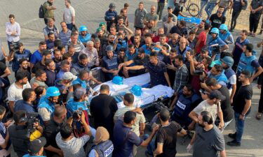 Mourners carry the bodies of Palestinian journalists Mohammed Soboh and Saeed Al-Taweel