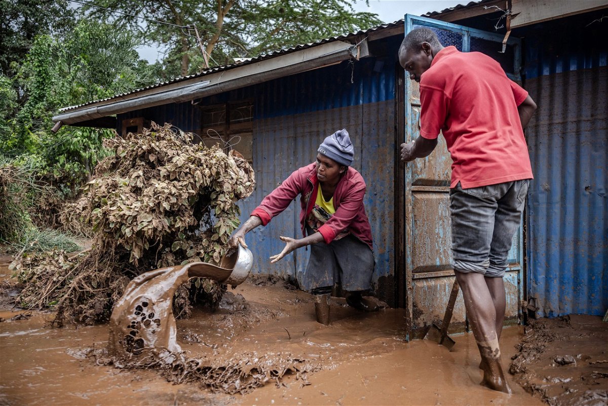 <i>Luis Tato/AFP via Getty Images via CNN Newsource</i><br/>People removing mud and water from their house in Mai Mahiu
