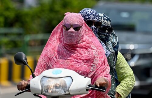 Women cover their faces with a cloth on a hot day