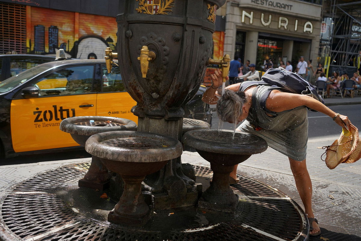 <i>Bruna Casas/Reuters via CNN Newsource</i><br/>A tourist cooling down in a fountain amid a heatwave in Barcelona