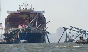 A section of the Francis Scott Key Bridge rests in the water next to the Dali container ship in Baltimore on May 13