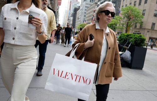 People walk along Fifth Avenue with shopping bags on May 8 in New York City. Inflation cooled back down in April