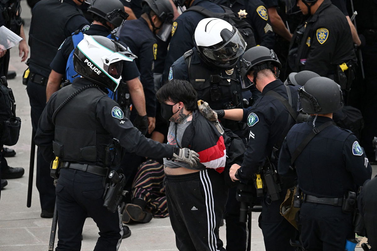 <i>Patrick T. Fallon/AFP/Getty Images via CNN Newsource</i><br/>Police detain a pro-Palestinian demonstrator as they clear an encampment after protesters surrounded the Physical Sciences Lecture Hall at the University of California