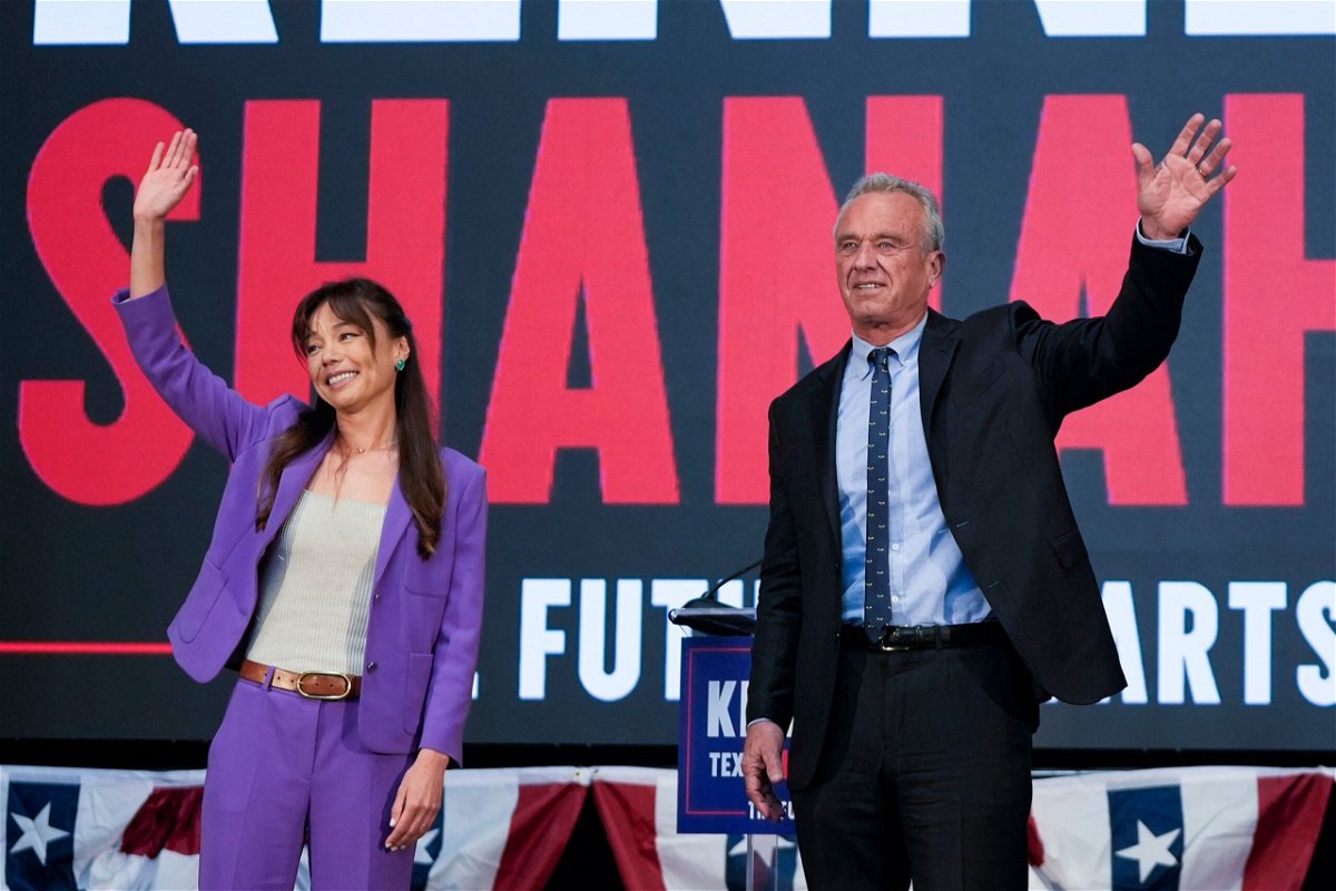 <i>Eric Risberg/AP via CNN Newsource</i><br/>Robert F. Kennedy Jr. and Nicole Shanahan wave onstage during a campaign event in Oakland