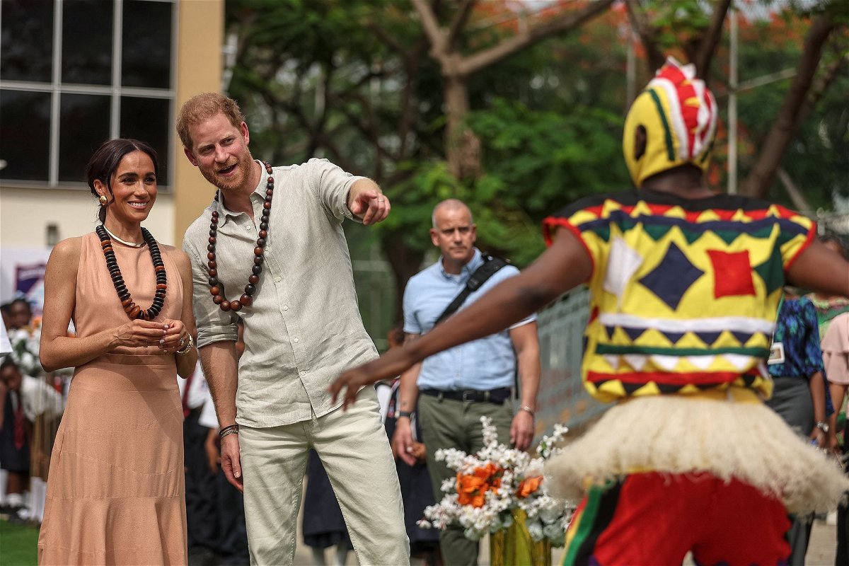 <i>Kola Sulaimon/AFP/Getty Images via CNN Newsource</i><br/>The Duke and Duchess of Sussex are welcomed to the Lightway Academy in Abuja by dancers on Friday.