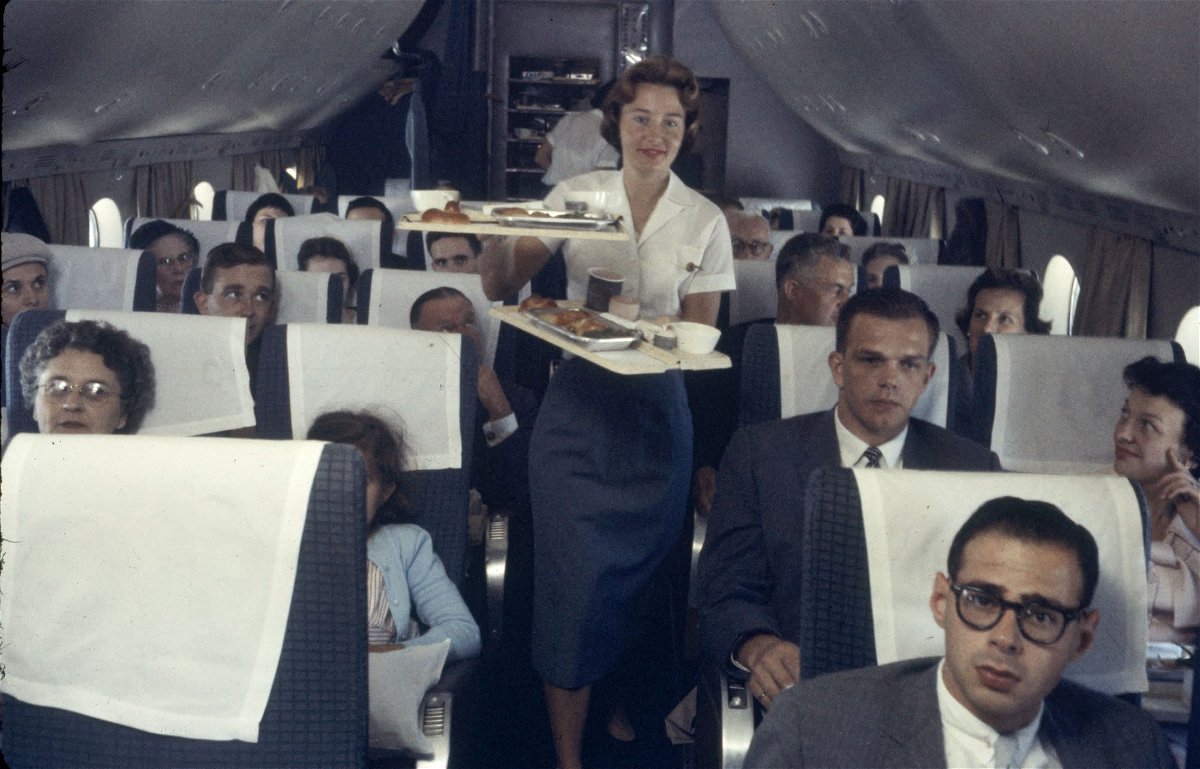 <i>Peter Stackpole/The LIFE Picture Collection/Shutterstock via CNN Newsource</i><br/>A Pan American Airline flight attendant serves trays of food to passengers on a plane in 1958.