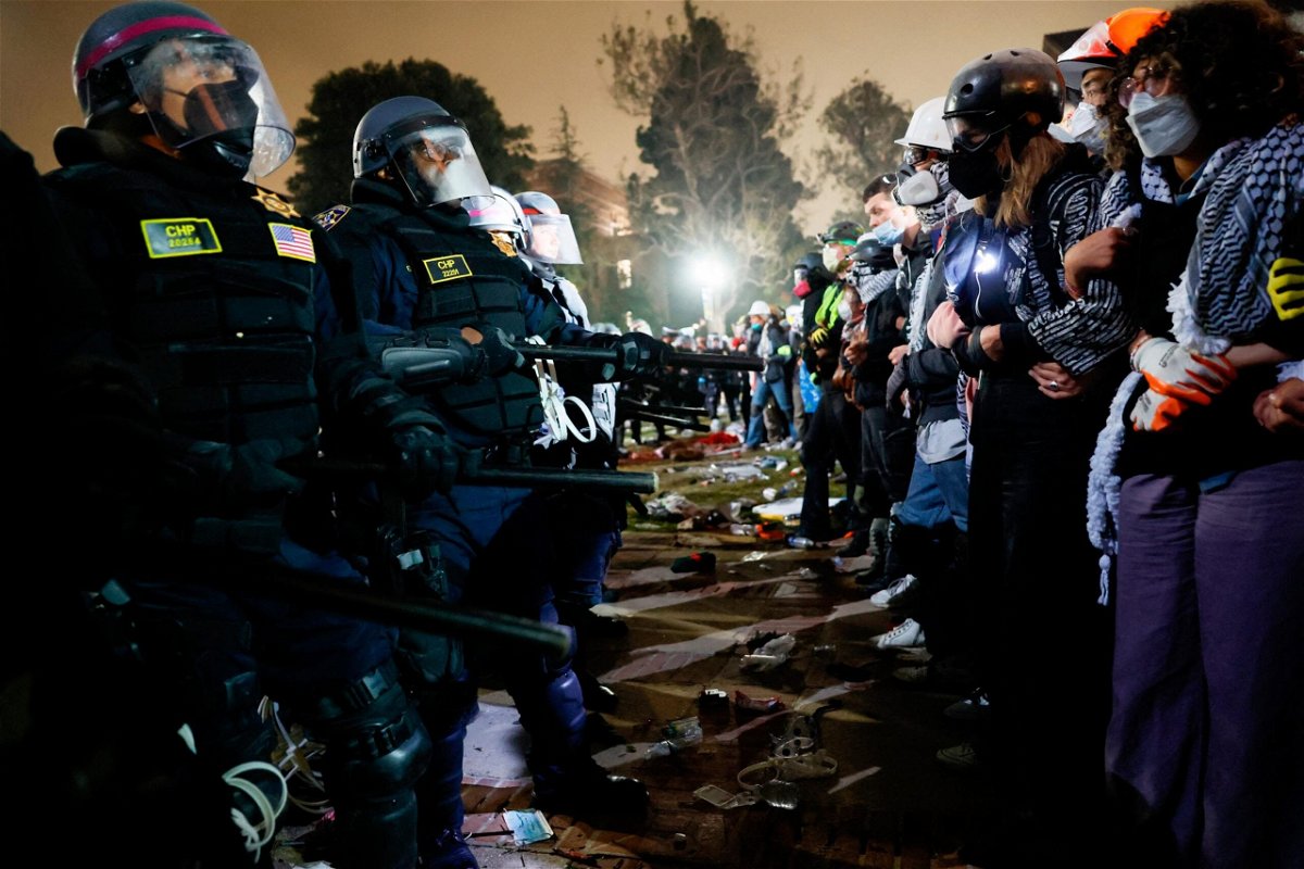 <i>Etienne Laurent/AFP/Getty Images via CNN Newsource</i><br/>Police face-off with pro-Palestinian students after destroying part of the encampment barricade on the campus of the University of California