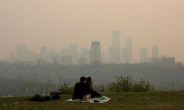 Smoke from wildfires blankets the city as a couple has a picnic in Edmonton