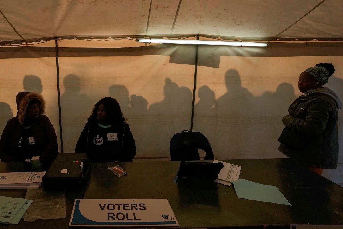 <i>Themba Hadebe/AP via CNN Newsource</i><br/>Electoral workers prepare to open the voting station as voters line up to cast their ballot for general elections in Alexandra