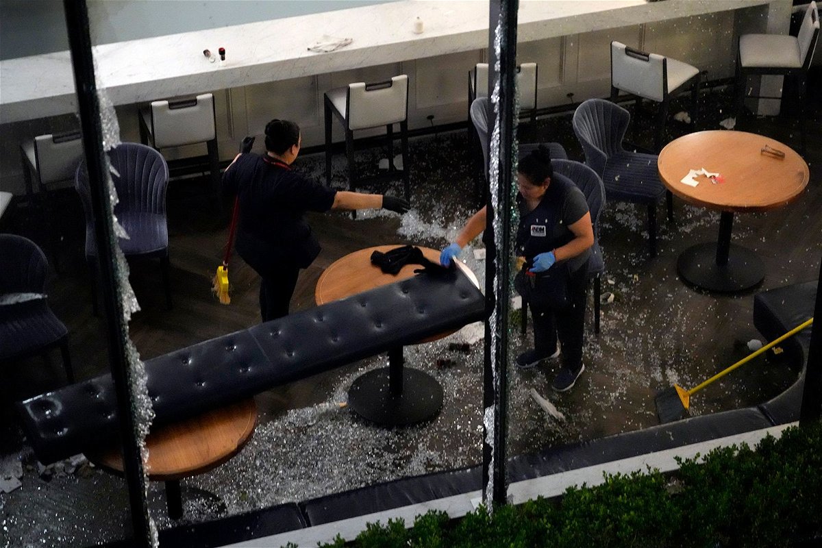<i>David J. Phillip/AP via CNN Newsource</i><br/>Workers clean up broken glass inside a damaged downtown restaurant after a severe thunderstorm Thursday in Houston.