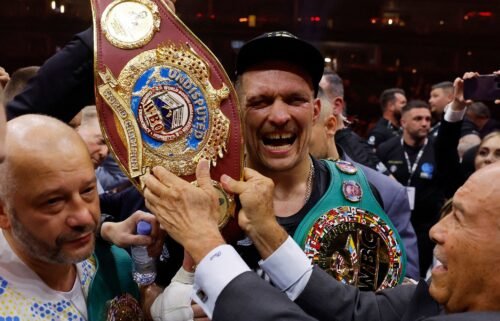 Oleksandr Usyk celebrates with the belts after becoming the undisputed heavyweight world champion.