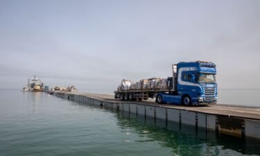 A truck carries humanitarian aid across Trident Pier