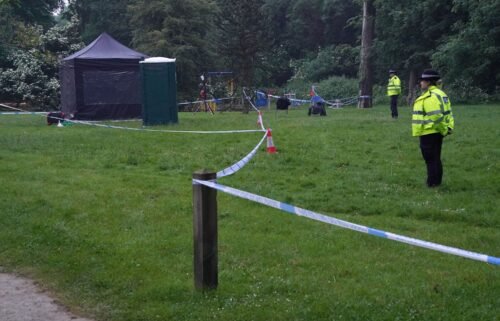 Police next to a black forensics tent in Grenfell Park