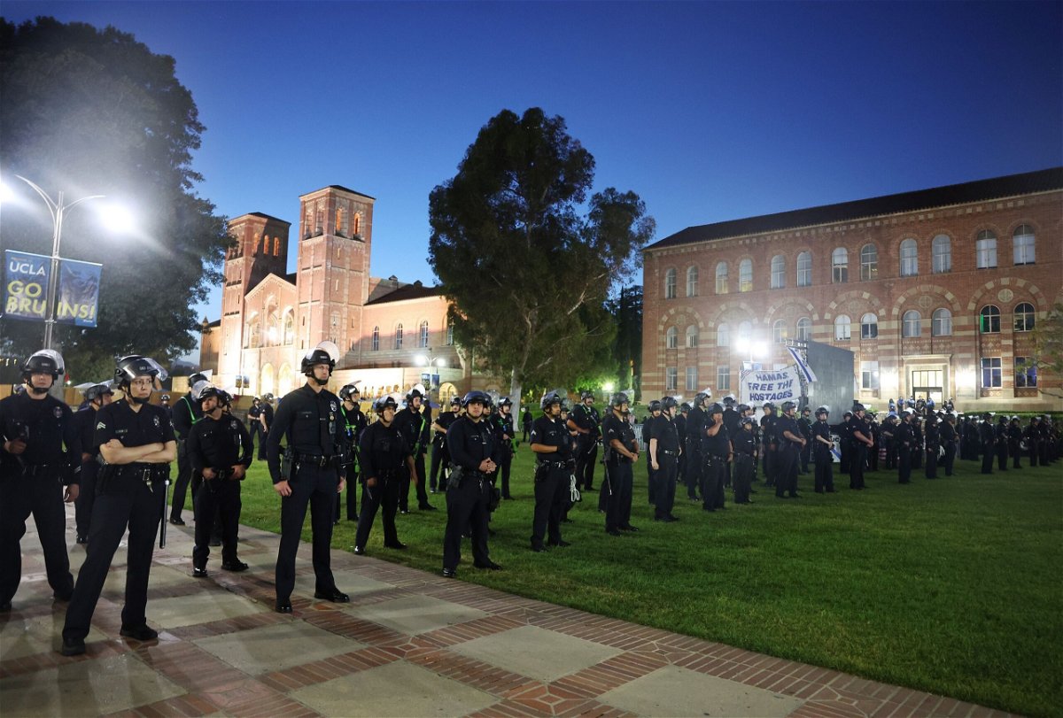 <i>Mario Tama/Getty Images via CNN Newsource</i><br/>LAPD officers keep watch near a pro-Palestinian encampment at the University of California