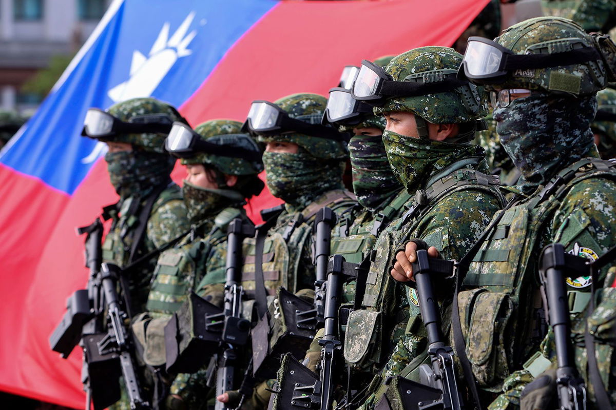 <i>Daniel Ceng/AP via CNN Newsource</i><br/>Soldiers pose for group photos with a Taiwan flag after a preparedness enhancement drill simulating the defense against Beijing's military intrusions in Kaohsiung City