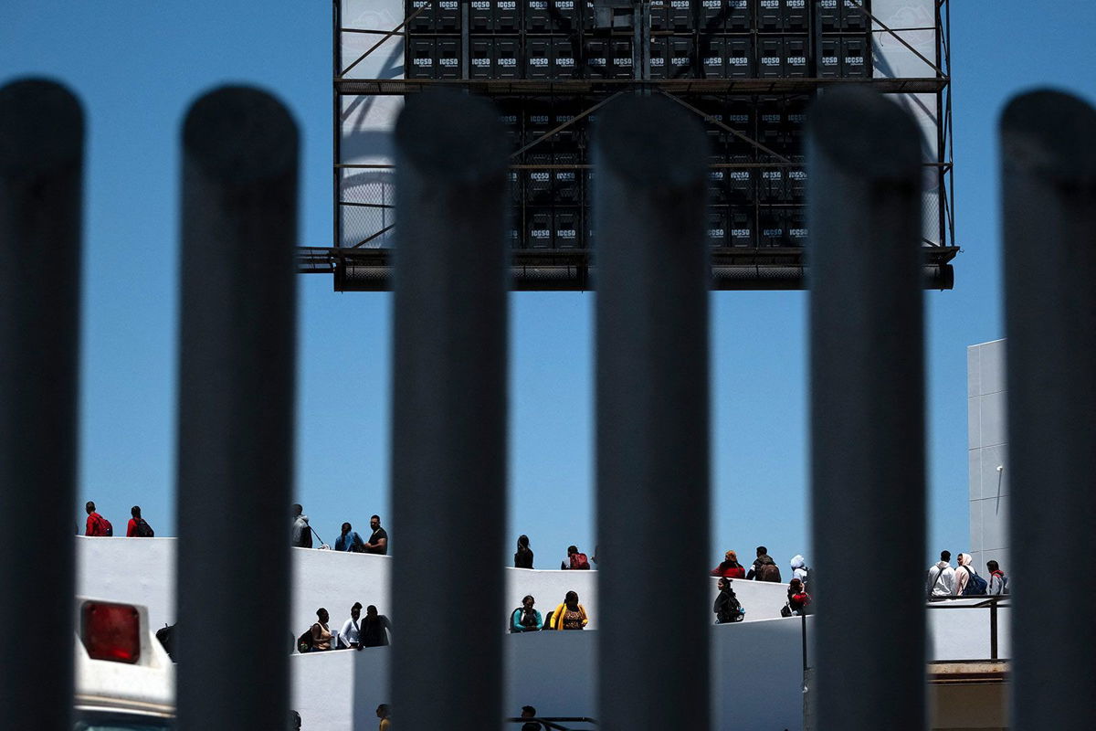 <i>Guillermo Arias/AFP/Getty Images via CNN Newsource</i><br/>Asylum seekers at the El Chaparral crossing port in Tijuana