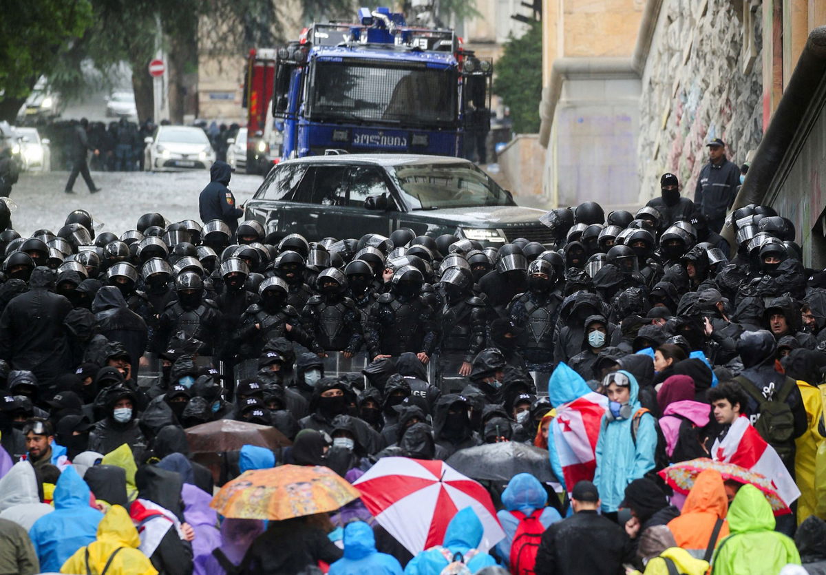 <i>Irakli Gedenidze/Reuters via CNN Newsource</i><br/>Protesters stare down riot police outside the Georgian Parliament.