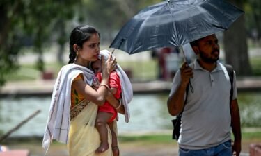 A woman shields her child from the sun during a heat wave in New Delhi on Wednesday.