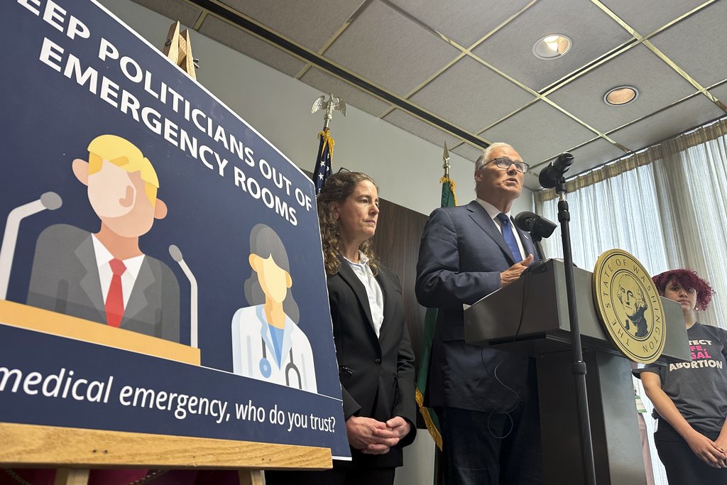 Washington Gov. Jay Inslee speaks to reporters during a news conference in Seattle on Tuesday as abortion rights supporters listen. (AP Photo/Gene Johnson)