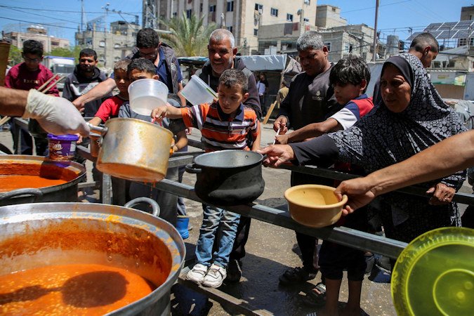Palestinians gather to receive food cooked from a charity kitchen in Rafah, southern Gaza, on May 8.