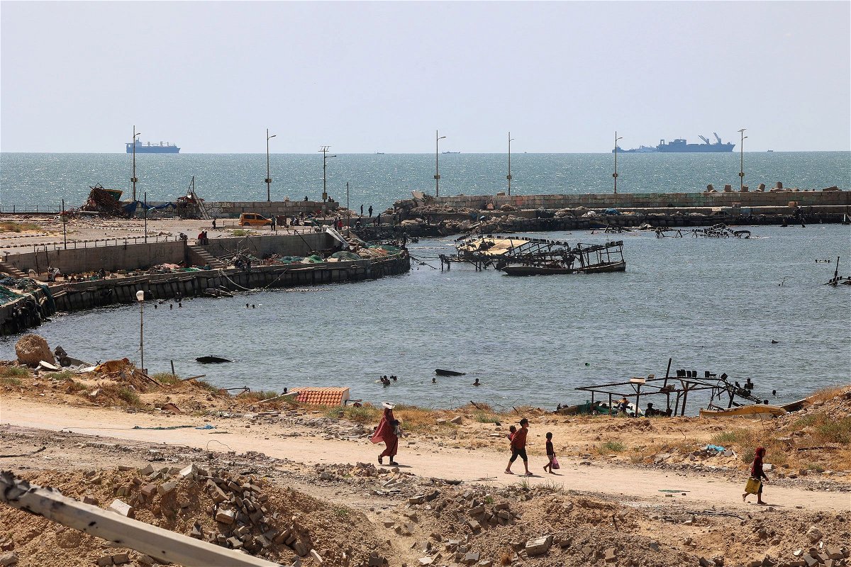 <i>AFP/Getty Images via CNN Newsource</i><br/>Palestinians walk past a jetty in Gaza City with a view of navy vessels off the coast as part of a humanitarian 