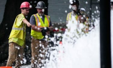 Crew members look at a broken water transmission line on Saturday