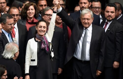 Mexican President Andres Manuel Lopez Obrador (R) raises the hand of Claudia Sheinbaum (L)