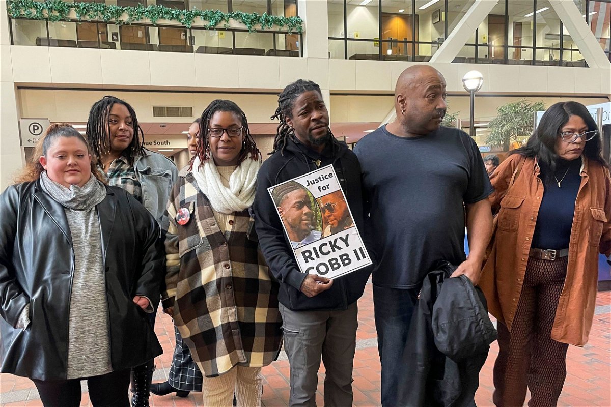 <i>Trisha Ahmed/AP via CNN Newsource</i><br/>Family and activists for Ricky Cobb II stand with a sign saying 