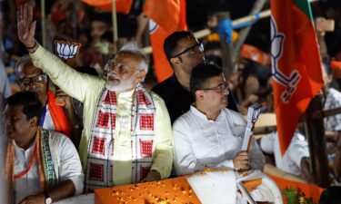 India's Prime Minister Narendra Modi waves to supporters during a roadshow as part of an election campaign