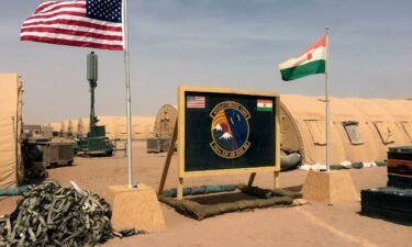 The flags of the United States and of Niger are raised side by side at the base camp for air forces and other personnel supporting the construction of Niger Air Base 201 in Agadez in April 2018.