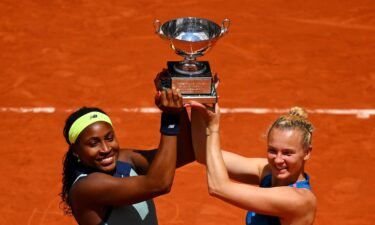 Coco Gauff and Katerina Siniakova celebrate with the trophy after victory.