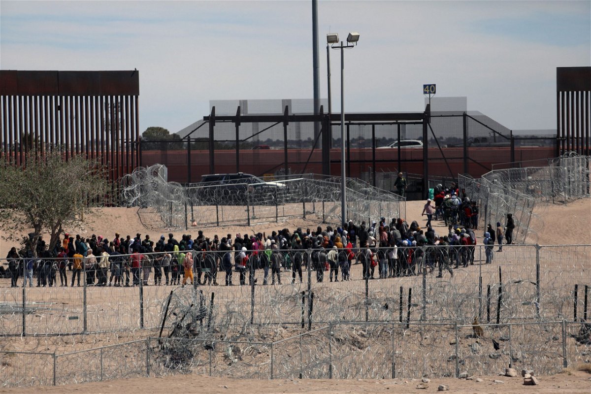 <i>Herika Martinez/AFP/Getty Images via CNN Newsource</i><br/>Migrants line up to be transferred by US Border Patrol in El Paso