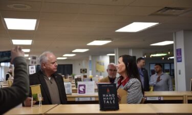 Minnesota Gov. Tim Walz speaks to a library specialist in March 2024 at Como Senior High School in St. Paul